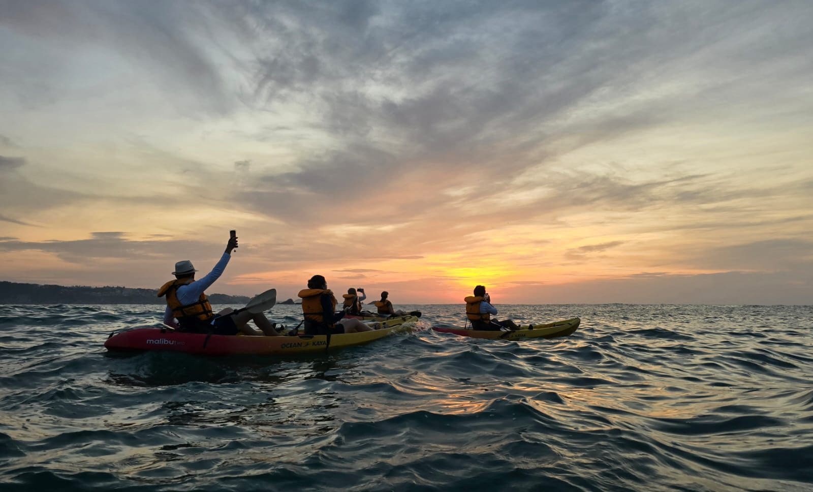 Kayakers paddling on the sea at sunrise in Huatulco